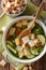 Light dietary soup with croutons close-up in a saucepan. Vertical top view