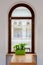 Light dining room with half circle wood window with table and green flowers on the windowsill