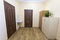 Light empty corridor hall with wooden floor, brown doors and sink. School, office or clinic interior