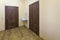 Light empty corridor hall with wooden floor, brown doors and sink. School, office or clinic interior