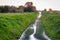 Light fog over a ditch with water, rural landscape at sunset