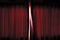 The light go through the about open dark red color curtain of the stage before performing.