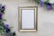 Light gold frame mockup and lilac on gray wash background flat lay copy space