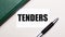 On a light gray background lies a pen, a green notebook and a white card with the text TENDERS. Business concept