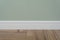 Light green matte wall, white baseboard