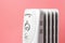 Light grey heater on a pink background, front view