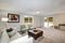 Light grey living area with green chairs and leather ottoman