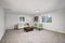 Light grey living area with green chairs and leather ottoman