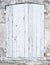 Light grey or white old shutters in limestone wall of french provence house