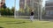 A light-haired girl plays on the field at the football goal with a soft toy