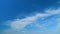 Light high clouds slide on sky. Layer of clouds in blue sky moving horizontal in opposite direction. Time lapse.