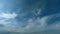 Light high clouds slide on sky. Layer of clouds in blue sky moving horizontal in opposite direction. Timelapse.