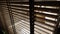 Light inside bathroom and wooden window blinds, sunshine and shadow on window blind and Granite tile wall