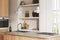 Light kitchen interior with bar island and kitchenware, shelf and window