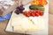 Light meal on rustic wooden board with german bread, cheese, mozzarella, fruits and vegetables