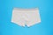 Light men`s underpants on a light blue background. Minimal concept of men`s underwear