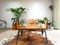 Light modern living room with a brown leather couch and numerous houseplants creating an urban jungle