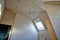 Light multistage ceiling in a modern attic room with a Dormer window