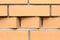 Light orange brick wall with curly masonry in the form of stepped strip