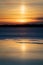 Light pillar in sunset reflecting from melting lake water