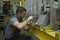 Light planes assembly hall. Worker making holes with a drill on a body plane for further riveting