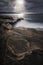 Light pouring down onto the rocks and the ocean on the coast