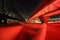 Light Rail Bridge Bathed in Red Light with a Lake in the Background