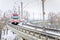 Light Rail Train on a Curving Bridge on a Snowy Winter Day