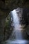 Light shining through waterfall in a an ancient cave