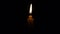 The light of a single candle flame swayed in the soft breeze and was beautifully lit in the darkness.