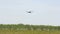 Light single-engine aircraft takes off from the green field into the sky