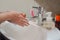Light-skinned Asian woman washing foamy hands in the bathroom sink with soap.