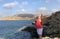 Light-skinned girl in a pink t-shirt on the shore of a popular place on the coast of Cyprus