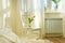 Light spring bedroom interior, bed, white chair, glass with yellow tulip