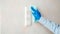Light switch surfaces disinfection. Woman in rubber blue glove clean light switch with cloth on wall by wet rag. New normal Covid