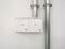 Light switches on white wall and metal tubes. Industrial and modern design