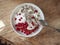 A light and tasty Breakfast with homemade cottage cheese, seeds and berry jam in a white plate on a rough wooden background from