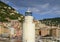 Light tower with seagull on top on a jetty with Camoglia in the background, Italy