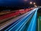 Light trails of the cars on a motorway at night. Seeing motion blurred of the car headlights and taillights on the multiple lanes
