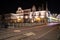 Light trails marks after passing tram, calm water canal and old medieval buildings at night, Ghent, Belgium