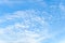 Light translucent cirrocumulus clouds high in a blue sky as a background. Day scenic skyscape of good sunny weather. Full frame