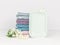 Light turquoise ceramic soap dish with multicolored soft towels and flowers. Bathroom wellness spa concept