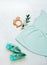 Light turquoise dress and shoes for baby girl and wooden teether on light marble background with copy space