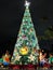 Light up in green light at night 50-foot Norfolk pine Christmas Tree surrounded by bears in uniform