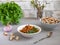 A light veggie snack of stewed carrots with parsley and garlic in a deep plate with crackers and leafy patch in the background,