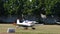 Light vintage airplane landing on the grass airstrip of a countryside airport