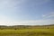 Light white clouds in the warm summer sky over village with small houses far away in the fields. Travelling. People living