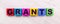 On a light wooden background, multi-colored wooden cubes with the text GRANTS