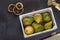 Light wooden container with pears of various species on a black autumn background