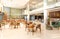 Light wooden and marble tile floor interior of modern cafe with double ceiling height. Lobby bar in hotel hall with split level